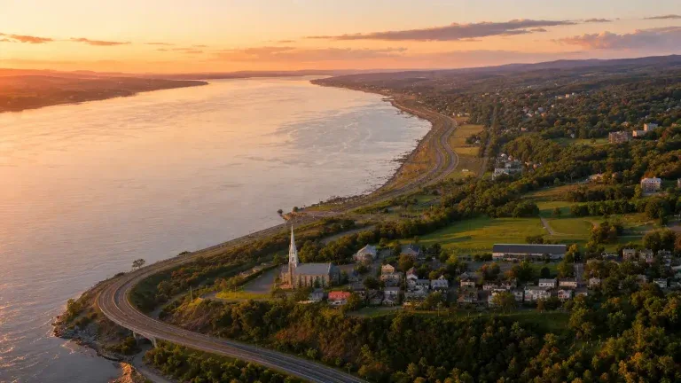 Vue aérienne d’un quartier en bordure d’un fleuve au coucher du soleil.