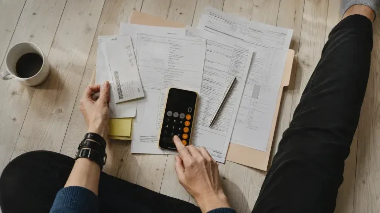 Mains près de factures et d’une calculatrice.