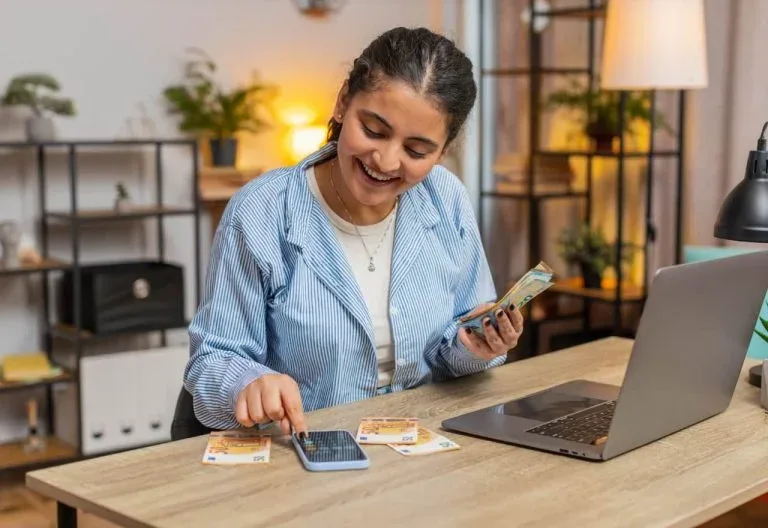 Personne utilisant un téléphone et une calculatrice.