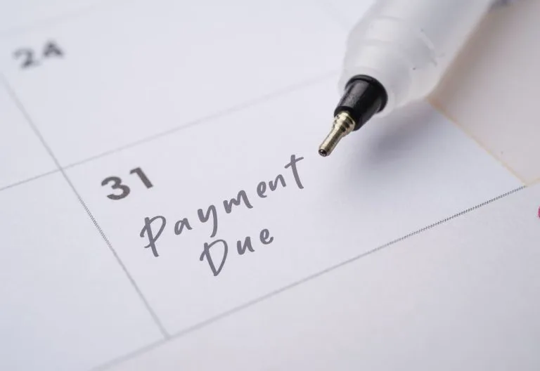Stylo sur un calendrier portant une note de paiement.