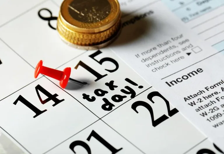 Calendrier, documents fiscaux et pièces de monnaie.