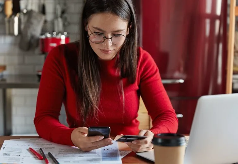 Personne consultant un téléphone et des documents.